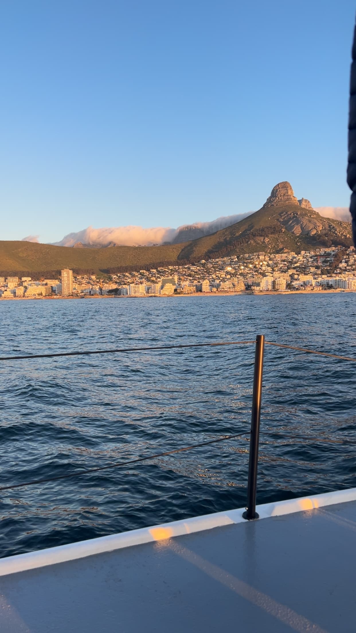 Lion's Head and coastline from a boat at golden hour, Cape Town