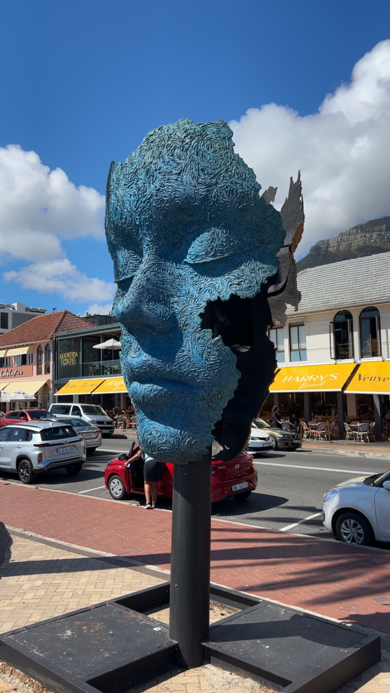 Blue face sculpture on the street, Camps Bay